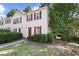 Inviting townhouse featuring neutral siding, complemented by red shutters and a well-maintained front lawn and mature trees at 3371 Spring Harbour Dr, Atlanta, GA 30340