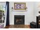 Elegant white fireplace with a dark hearth, artwork above, and a glimpse of the outdoor patio through sheer curtains at 3371 Spring Harbour Dr, Atlanta, GA 30340