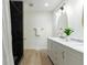 Modern bathroom with white vanity, double sinks, and a beautifully tiled shower at 398 Baker Nw Cir, Atlanta, GA 30318