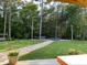 Spacious backyard with a stone pathway, lush lawn, mature trees, and an inviting outdoor lounge area at 605 Red Leaf Way, Canton, GA 30114