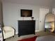 Bedroom features a mounted TV, dresser, accent chair, and a modern arched mirror at 605 Red Leaf Way, Canton, GA 30114
