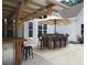 Inviting outdoor bar area with seating, umbrella, and custom-built wooden structure for relaxing and entertaining at 605 Red Leaf Way, Canton, GA 30114
