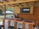 Outdoor bar area with mounted TV, wooden cabinets, and countertop seating at 605 Red Leaf Way, Canton, GA 30114