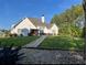Rear view of the home showcasing its well-maintained lawn, stone pathway, and outdoor entertainment area at 605 Red Leaf Way, Canton, GA 30114