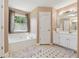 Bright bathroom features a soaking tub, large mirror, and white cabinets at 1093 Forest View Sw Ln, Lilburn, GA 30047