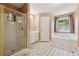 Light-filled bathroom with a walk-in shower, garden tub, and neutral decor at 1093 Forest View Sw Ln, Lilburn, GA 30047
