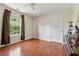 Simple bedroom featuring wood flooring, neutral paint, and a window with wood views at 1093 Forest View Sw Ln, Lilburn, GA 30047