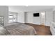 Modern bedroom featuring hardwood floors, neutral paint, large window, and an ensuite bathroom at 118 Via Roma, Woodstock, GA 30188