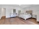 Open bedroom with wood floors, neutral paint, decorative bed frame, dresser, and plenty of sunlight at 118 Via Roma, Woodstock, GA 30188