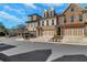 Beautiful three-story townhome with brick and stone facade, private garages, and well-maintained landscaping at 118 Via Roma, Woodstock, GA 30188