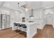 Bright kitchen features an island, stainless steel appliances, pendant lights, and wooden floors at 118 Via Roma, Woodstock, GA 30188