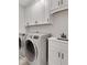 Well-equipped laundry room with modern washer and dryer, plus ample cabinet space at 118 Via Roma, Woodstock, GA 30188