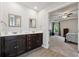 Bathroom featuring double sinks, white countertops, brown cabinets and a view into the primary bedroom at 211 Serendipity Way, Dallas, GA 30157