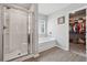Bright bathroom featuring a glass shower, soaking tub, and access to a walk-in closet at 211 Serendipity Way, Dallas, GA 30157