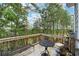 Wooden deck overlooking trees with a table and chairs at 211 Serendipity Way, Dallas, GA 30157