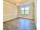 Empty dining room with hardwood floors, chandelier, and wainscoting, perfect for entertaining at 211 Serendipity Way, Dallas, GA 30157