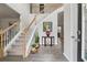 Bright foyer with hardwood floors, staircase, and decorative table, creating a welcoming entrance at 211 Serendipity Way, Dallas, GA 30157