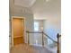 Upstairs hallway featuring wooden stair rails, neutral paint, carpet and an attractive light fixture at 211 Serendipity Way, Dallas, GA 30157