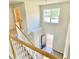 Upstairs hallway featuring wooden stair rails and banisters, and view to the front door and entry at 211 Serendipity Way, Dallas, GA 30157