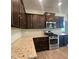 Kitchen featuring granite countertops, stainless steel appliances, and dark wood cabinets at 211 Serendipity Way, Dallas, GA 30157