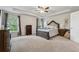 Large primary bedroom with a tray ceiling, neutral paint, carpet, ceiling fan and large windows at 211 Serendipity Way, Dallas, GA 30157