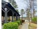 Outdoor pavilion area offers a serene retreat with covered seating and lush landscaping by a lake at 211 Serendipity Way, Dallas, GA 30157