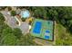 Aerial view featuring the community pool, tennis courts, and clubhouse nestled among mature trees at 431 La Perla Dr, Sugar Hill, GA 30518