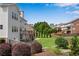 Exterior shot of backyard with a deck, patio, manicured shrubs, and a view of neighboring houses at 431 La Perla Dr, Sugar Hill, GA 30518