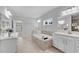 Bright bathroom features double vanities, soaking tub, neutral tile and tile floors at 431 La Perla Dr, Sugar Hill, GA 30518
