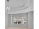 Bright bedroom featuring tray ceiling, a modern light fixture, and neighborhood views at 431 La Perla Dr, Sugar Hill, GA 30518