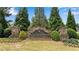 Stone monument marking the entrance to Ashford Crossing community surrounded by lush greenery at 431 La Perla Dr, Sugar Hill, GA 30518