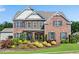 Beautiful brick home offers refined details, a lush lawn, and colorful, manicured landscaping at 431 La Perla Dr, Sugar Hill, GA 30518