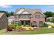 Stunning brick home features mature landscaping, a well-manicured lawn, and charming architectural details at 431 La Perla Dr, Sugar Hill, GA 30518