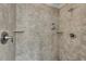 Close up of a tiled shower stall with wall mounted soap dispenser and shower head at 431 La Perla Dr, Sugar Hill, GA 30518