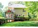 The backyard of the home featuring a cozy sunroom, lush lawn, and wooden deck at 51 Vienna Way, Douglasville, GA 30134