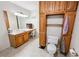 Bathroom features a vanity with sink, commode, built-in wooden cabinets, and tiled flooring at 51 Vienna Way, Douglasville, GA 30134