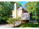 Side view of a tan two-story house with an enclosed sunroom, two car garage, and mature trees at 51 Vienna Way, Douglasville, GA 30134