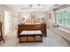 Spacious main bedroom suite with a king bed, tray ceiling, bench, and a window seat for ample natural light at 51 Vienna Way, Douglasville, GA 30134