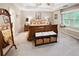 Spacious main bedroom suite with a king bed, tray ceiling, bench, and a window seat for ample natural light at 51 Vienna Way, Douglasville, GA 30134