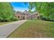 Beautiful brick home featuring a three-car garage, long driveway, and lush green lawn at 511 Etris Ct, Roswell, GA 30075