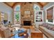 Cozy living room with stone fireplace, wood-beamed ceiling, and natural light at 511 Etris Ct, Roswell, GA 30075