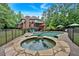 Backyard oasis features a pool, spa, lounge chairs, and seating with lush greenery, perfect for outdoor relaxation at 511 Etris Ct, Roswell, GA 30075