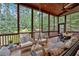 A screened-in porch with outdoor furniture, wood floors, wood ceiling and views of a wooded back yard at 511 Etris Ct, Roswell, GA 30075