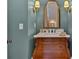 Stylish powder room featuring a unique vanity with a marble countertop and decorative mirror at 511 Etris Ct, Roswell, GA 30075