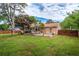 Large backyard with a paver patio, outdoor seating, mature trees, and a wood fence at 618 Nw Summerville Dr, Lawrenceville, GA 30046