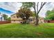 Green backyard with a wood fence, mature trees, patio seating, and rear view of the home at 618 Nw Summerville Dr, Lawrenceville, GA 30046