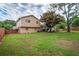 Spacious backyard with a wood fence, mature trees, and a view of the home's rear exterior at 618 Nw Summerville Dr, Lawrenceville, GA 30046