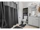 The cozy bathroom features a shower with gray curtain and a functional vanity with shelving and modern fixtures at 618 Nw Summerville Dr, Lawrenceville, GA 30046
