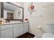 Bright bathroom featuring white cabinets, decorative wall art, and a large mirror above the vanity at 618 Nw Summerville Dr, Lawrenceville, GA 30046
