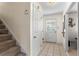 Hallway with tile floors leading to staircase, featuring a white door and trim at 618 Nw Summerville Dr, Lawrenceville, GA 30046